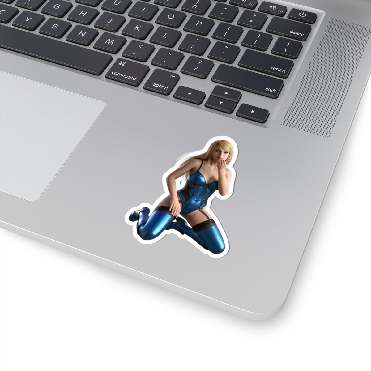 Samus Aran Sticker – Sci-Fi Game Vinyl Sticker for Laptops & Indoor Decor stuck on silver laptop showing glossy, detailed blue-suited character vinyl sticker