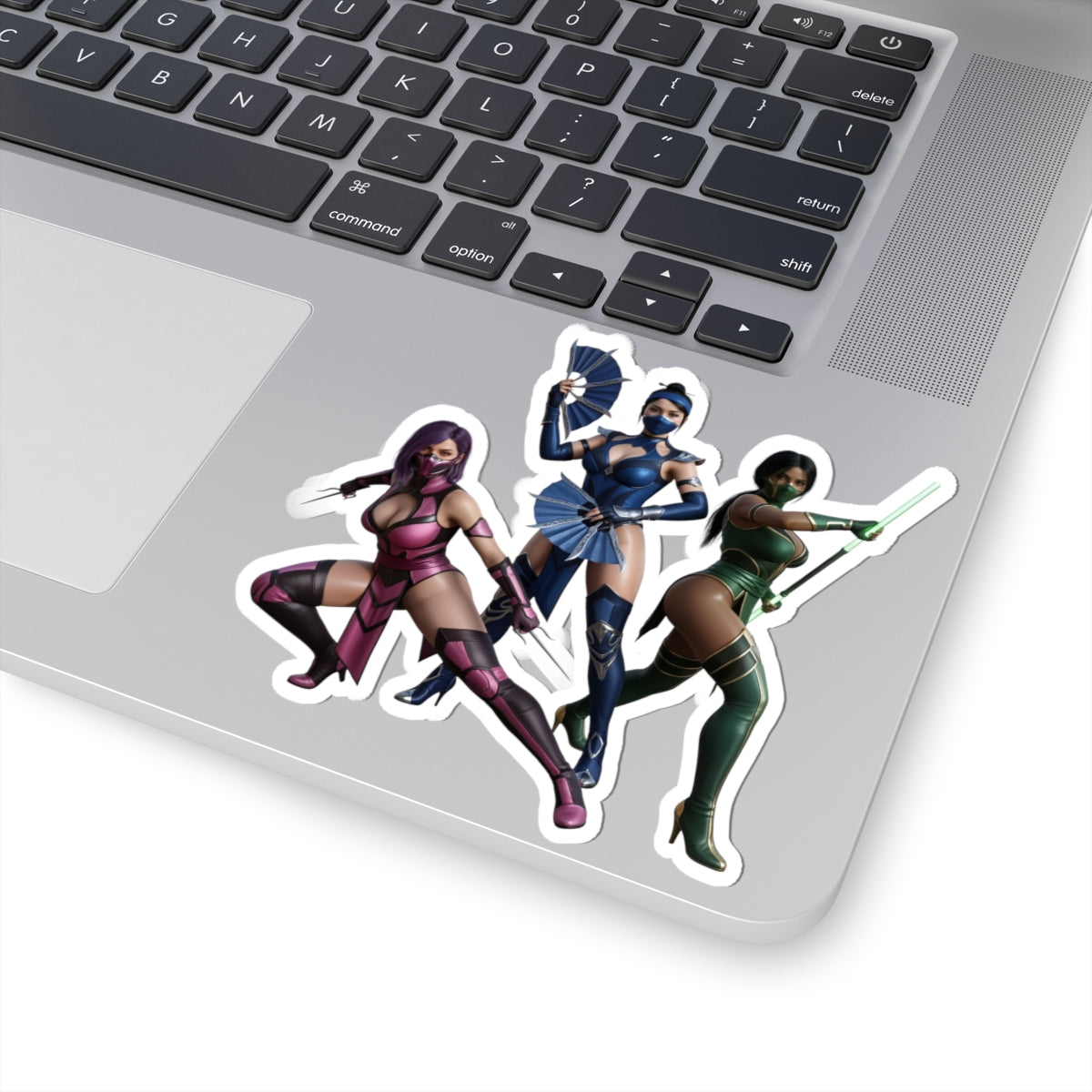 Kitana, Jade, Mileena Sticker – Mortal Kombat Vinyl Sticker for Laptops & Indoor Decor on silver laptop showing three female fighters in colorful costumes