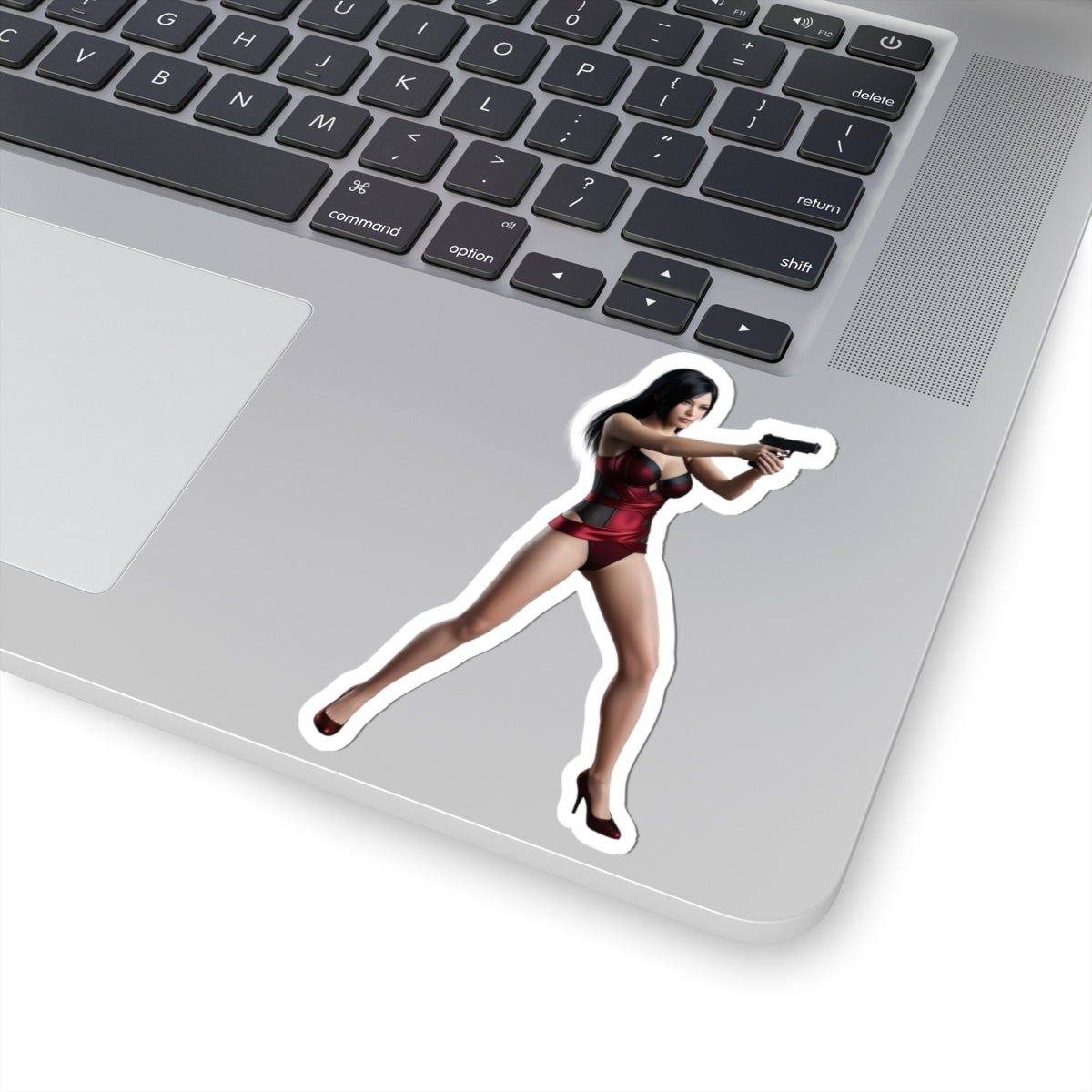 Ada Wong Sticker – Iconic Game Character Vinyl Sticker for Laptops & Indoor Decor showing glossy cutout vinyl decal of character aiming pistol on silver laptop