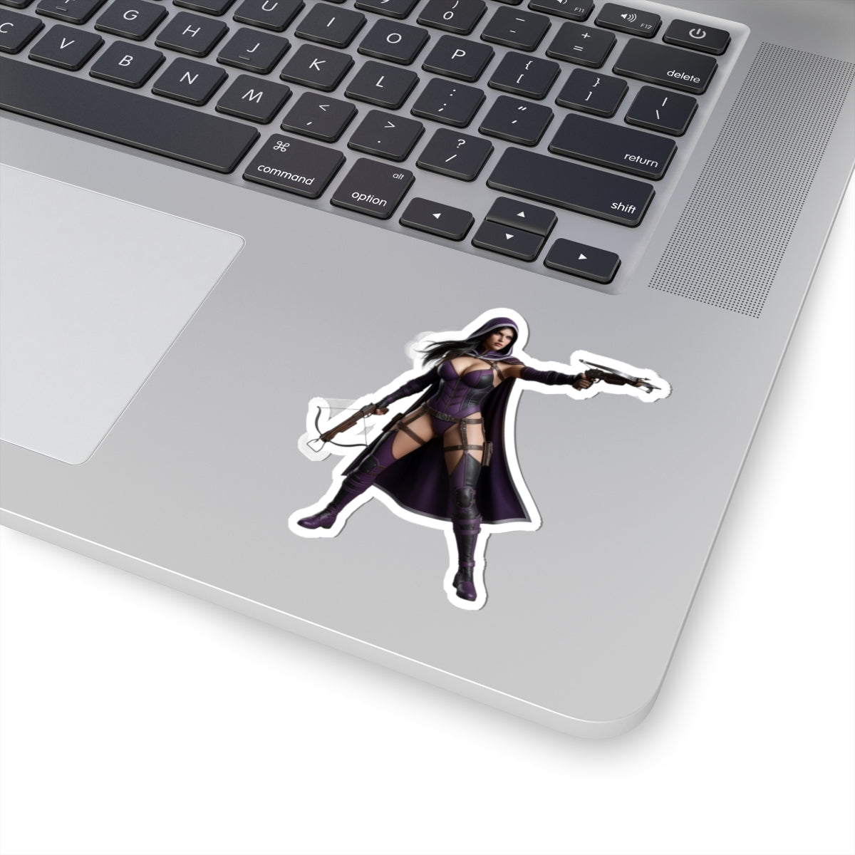 Huntress Sticker – Comic Heroine Vinyl Sticker for Laptops & Indoor Decor on silver laptop corner, glossy durable vinyl, vibrant comic-style heroine design