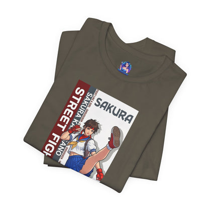 Sakura Kasugano T-Shirt | Street Fighter Anime Tee for Gamers & Fighting Game Fans - folded olive tee with energetic Sakura school-fighter illustration